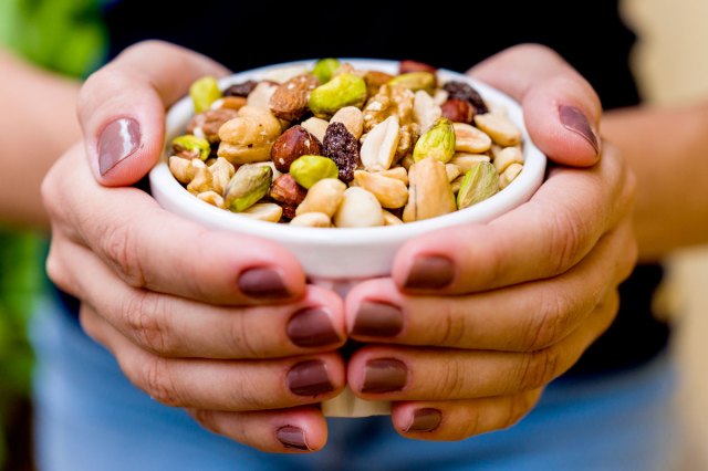 An image of a hands holding a bowl of nuts