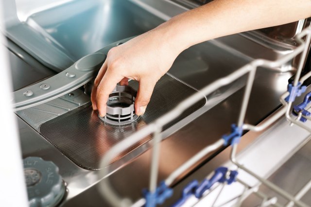 An image of a hand turning a dishwasher cap