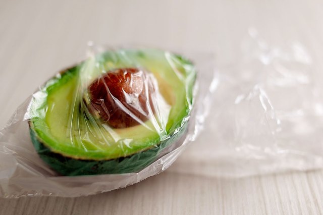 An image of half an avocado wrapped in plastic