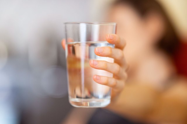 An image of a hand holding a glass of water