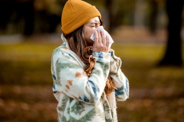 An image of a woman blowing her nose