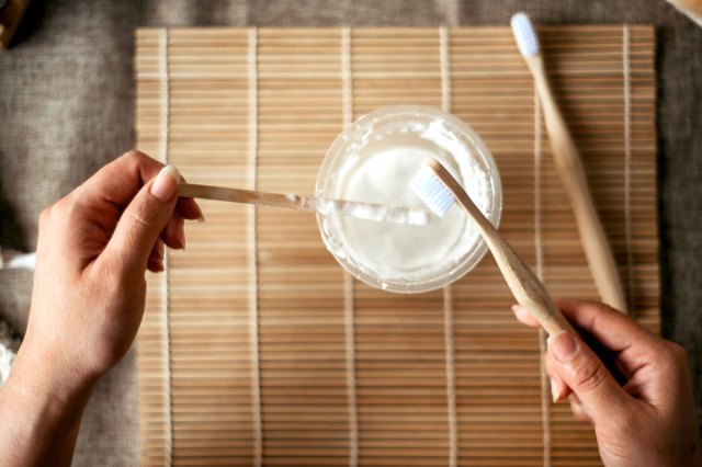 An image of hands holding wooden brush and tools