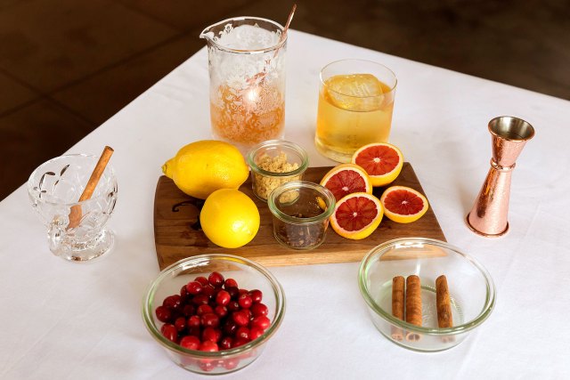 An image of ingredients for fall cocktails on white table cloth