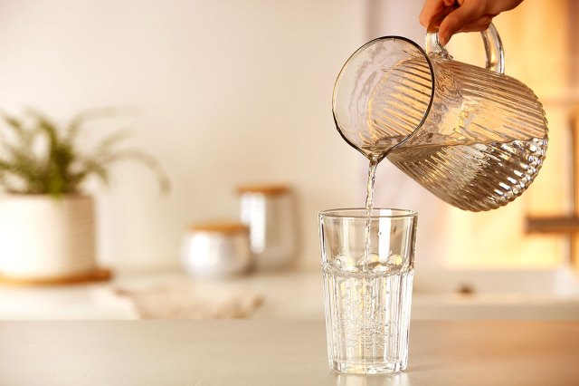 An image of a glass of water being poured from a pitcher