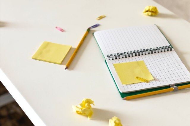 An image of an open notebook and Post-it notes