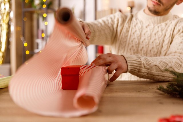 An image of a man wrapping a holiday present
