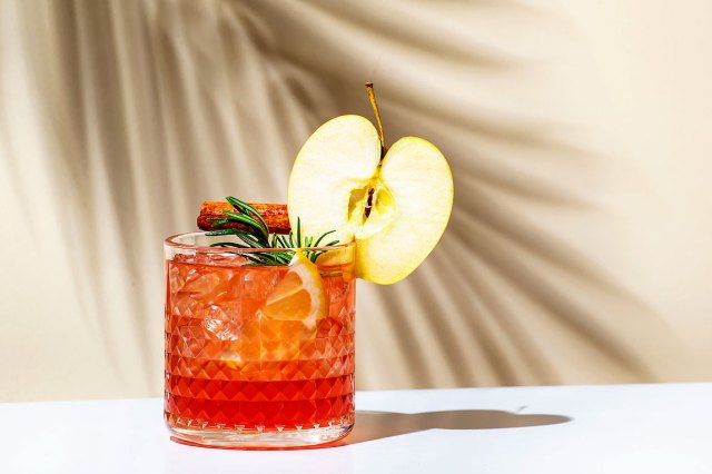 An image of a red drink garnished with an apple slice