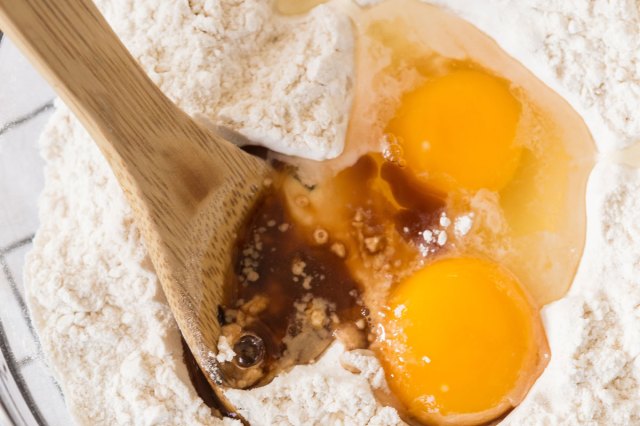 An image of eggs in a bowl of flour