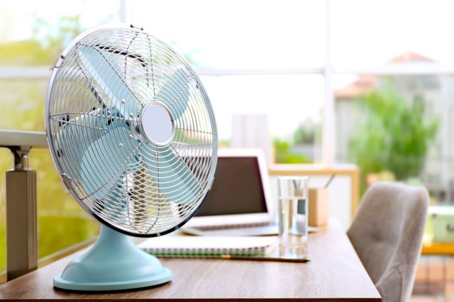 An image of a light blue fan on a desk