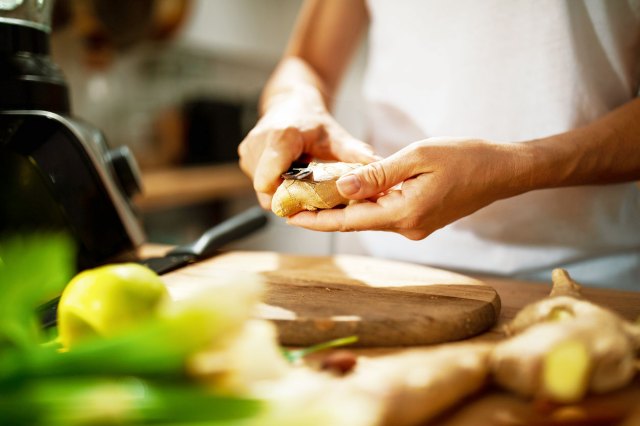 An image of a person peeling ginger in a kitchen