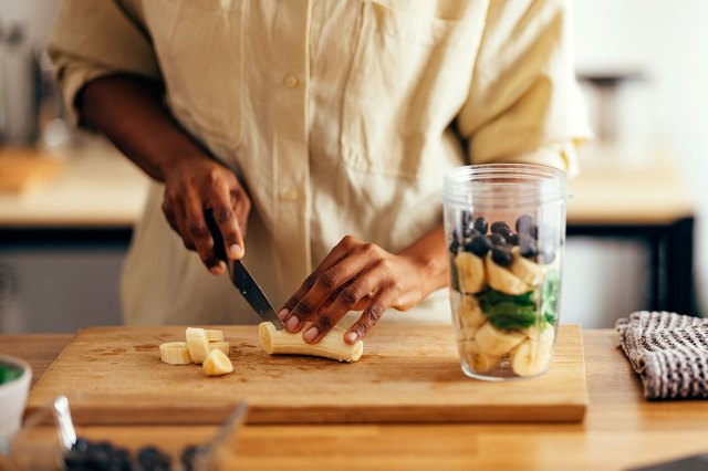 An image of a person slicing bananas for a smoothie