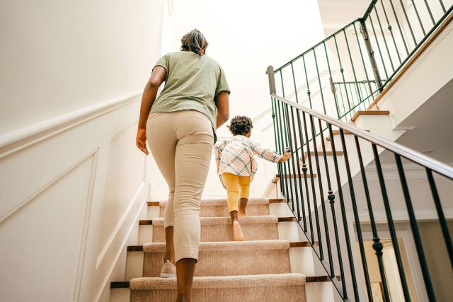 An image of a woman and a young girl walking up the stairs
