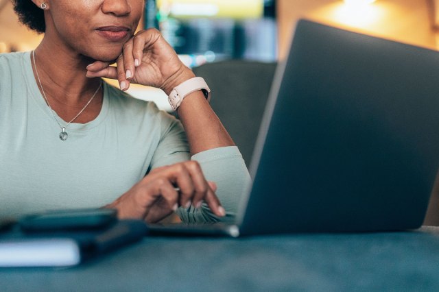 An image of a woman typing on a laptop