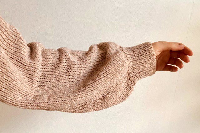 An image of an arm wearing a wool sweater