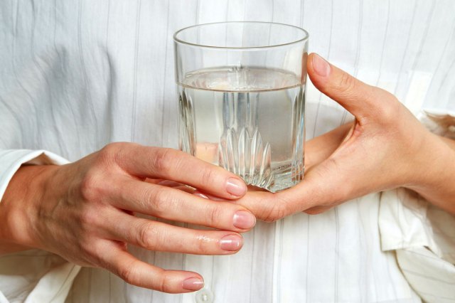 An image of a person holding a glass of water