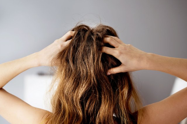 An image of a woman massaging her scalp