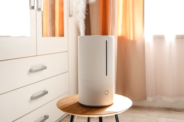 An image of a white humidifier on a stool in a bedroom