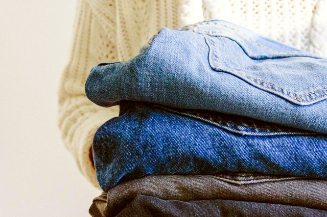 An image of a person holding a stack of jeans