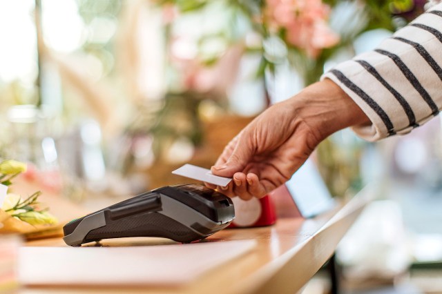 An image of a person tapping a machine with their credit card