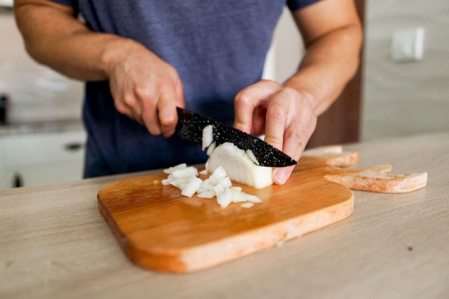 An image of a man cutting an onion