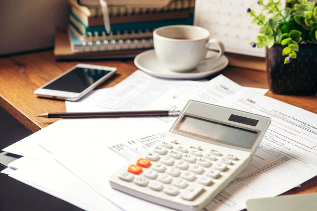 An image of a desk with paperwork and a calculator