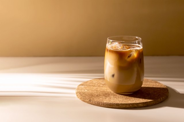 An image of an iced coffee on a cork trivet