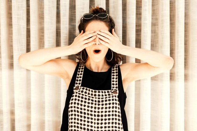 An image of a woman with her hands over her eyes