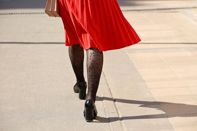 A woman in black stockings and a red skirt