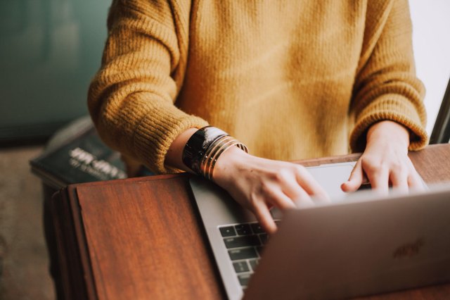 An image of a person typing on a laptop