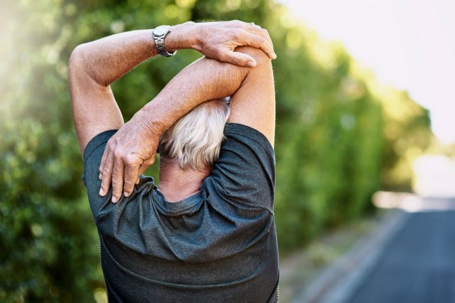 An image of a man stretching his arm behind his head