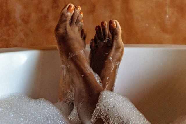 An image of two feet in a bathtub