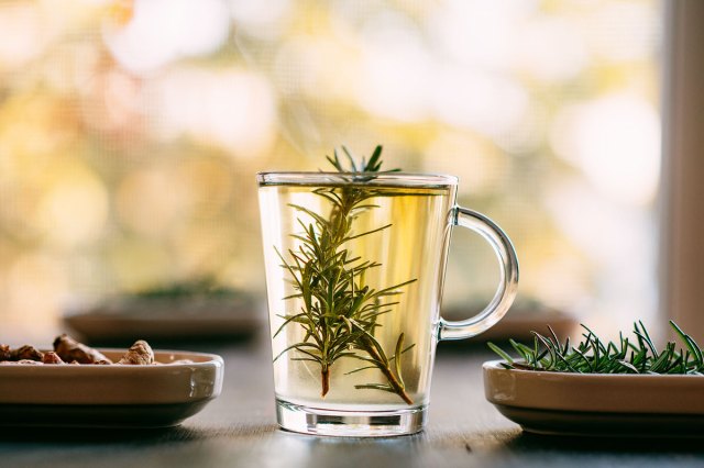 An image of a glass of liquid with a rosemary sprig