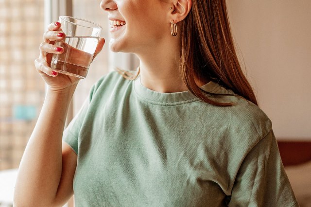 An image of a woman holding a glass of water