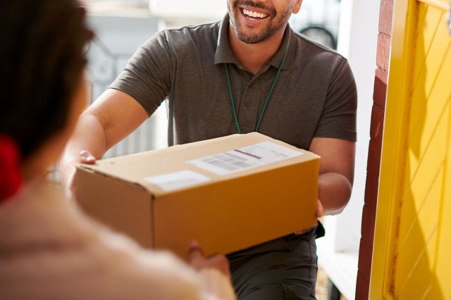 An image of a delivery man handing a box to a person