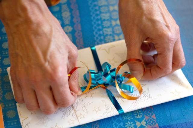 An image of a person typing a ribbon on a gift