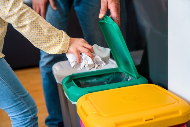 An image of a person thrown paper into a trash bin