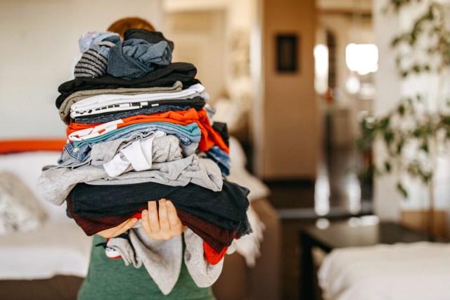An image of a person holding a stack of folded clothes