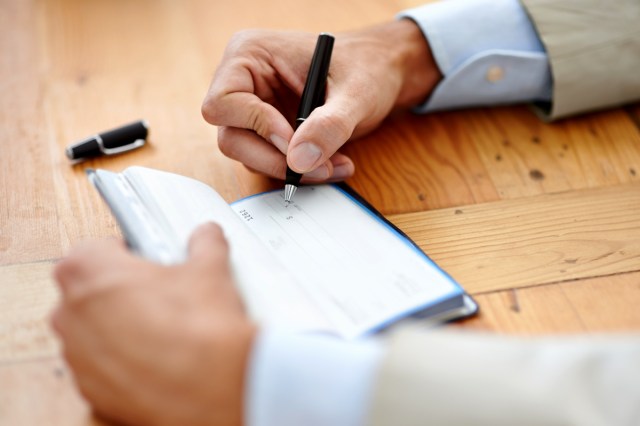 An image of a person writing a check