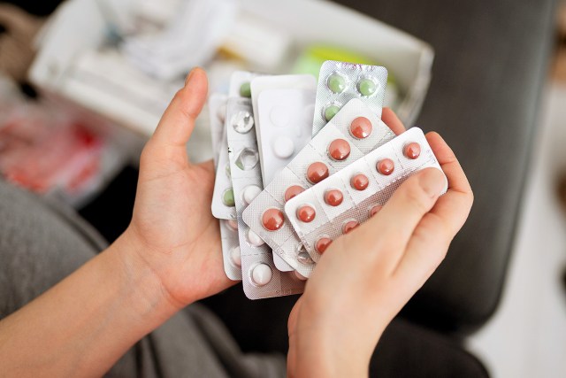 An image of two hands holding pill packets