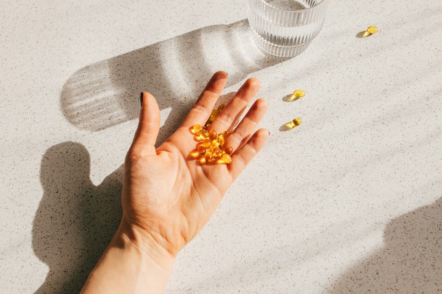 An image of a hand holding yellow pills