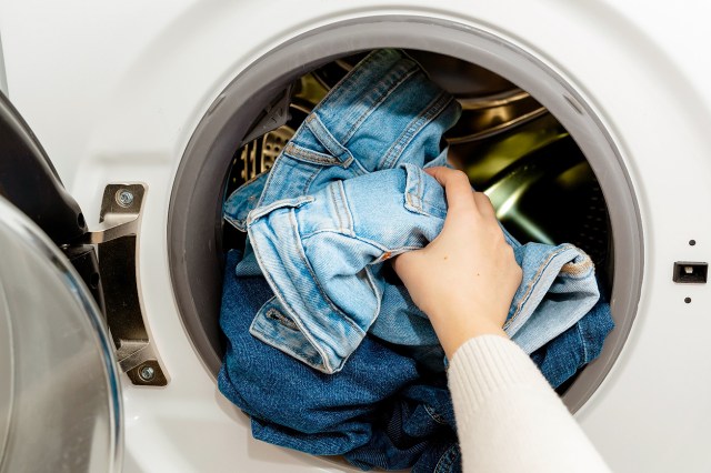 An image of a hand pulling jeans from the dryer