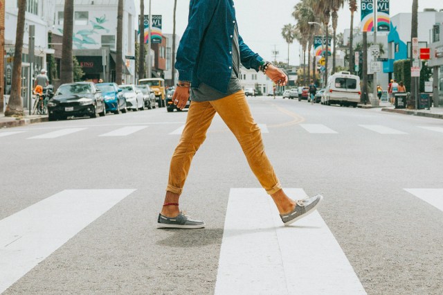 An image of a man walking across the street