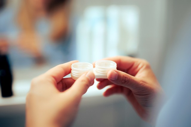 An image of a person holding a contact lens case