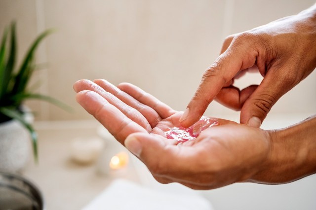 An image of a person dipping their finger in a palm of gel