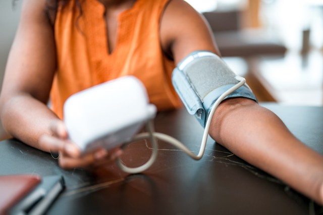 An image of a woman checking her blood pressure