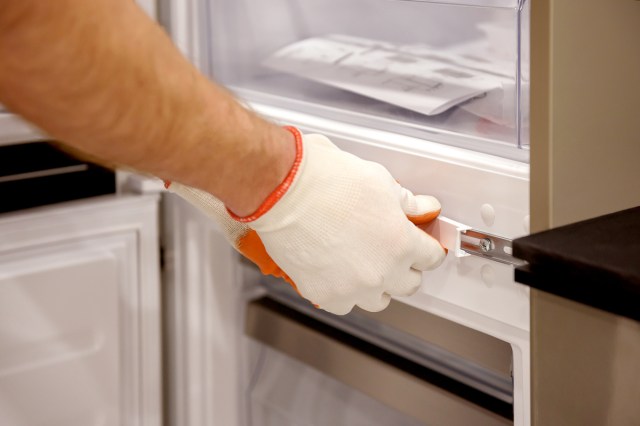 An image of a worker is fixing the built-in refrigerator