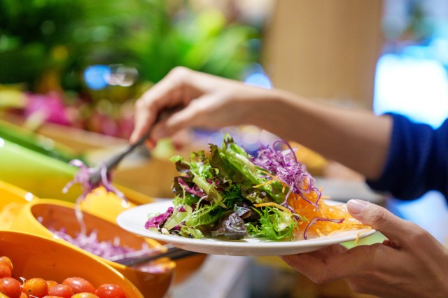An image of a person holding a plate with a salad