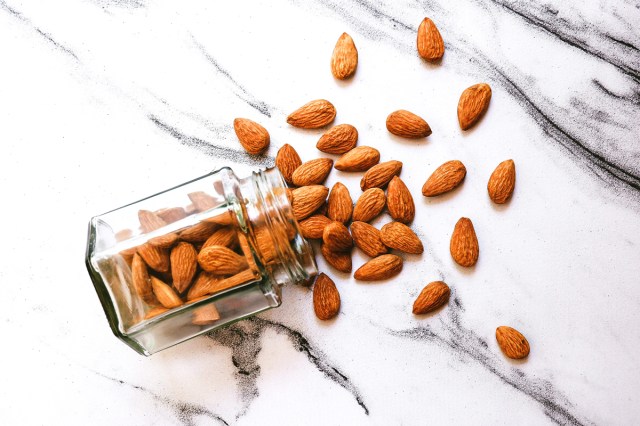 An image of almonds spilling out of a jar