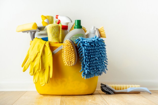 An image of cleaning supplies in a yellow bucket on the floor