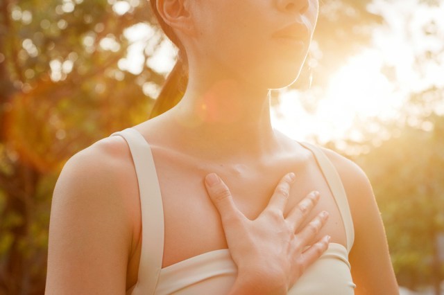 An image of a woman outside with her hand on her chest